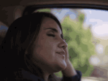 a close up of a woman 's face in a car