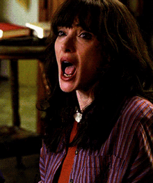 a woman in a striped shirt with her mouth wide open