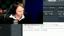 a man wearing headphones sits in front of a microphone in front of a computer screen