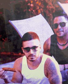 a man wearing sunglasses is holding a sausage in his hand