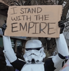 a storm trooper holding a sign that says i stand with the empire