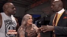 a man in a suit and tie is talking to a woman and a man in a tank top that says apollo