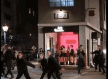 a group of people are walking in front of a store that says boy