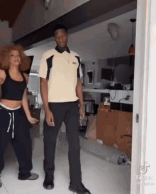 a man and a woman are dancing together in a living room .