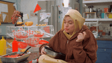 a woman sitting in front of a display of food with a sign on the refrigerator that says " no smoking "