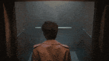 a man in a trench coat is standing in a dark room