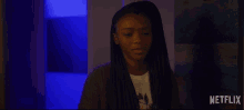 a woman in a dark room with a netflix logo on the bottom