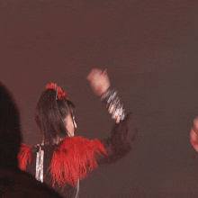a woman in a sequined top is holding her arms up in the air
