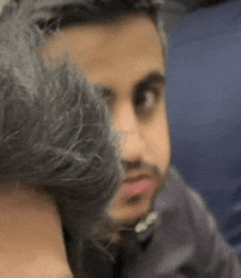 a man with a beard is hugging another man 's neck .
