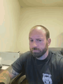 a bald man with a beard wears a shirt that says ' united states ' on it