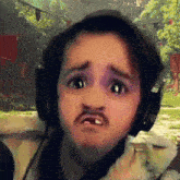 a man wearing headphones and a fake mustache makes a sad face