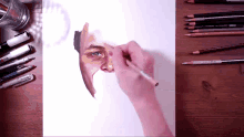a person is drawing a man 's face with a marker and pencils