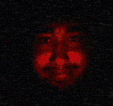 a close up of a person 's face with red lights behind them