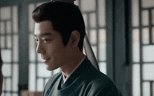 a man in a traditional costume is smiling and looking at another man in a room .