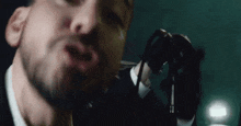 a close up of a man singing into a microphone