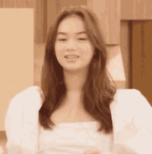 a close up of a woman wearing a white shirt and puffed sleeves .