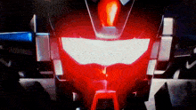 a close up of a robot 's head with a red light shining on it