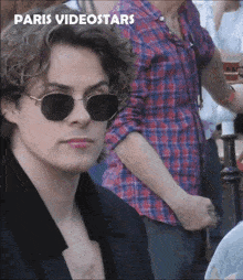 a man wearing sunglasses and a plaid shirt with the words paris videostars written above him