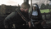 a man and a nun are standing next to each other in a video game .