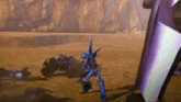 a blue robot is standing in the middle of a desert in a video game .