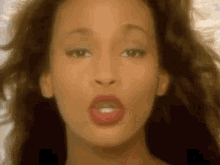 a close up of a woman 's face with red lipstick on her lips .