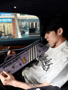 a man sitting in a car with a bag that says vibrant