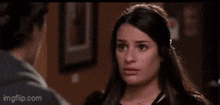 a woman is looking at a man in a room and making a face .