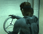 a man in a video game is holding a steering wheel with an x on it