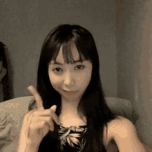a woman sitting on a couch giving the peace sign