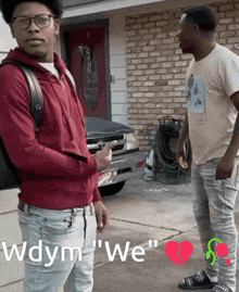 two men standing in front of a brick house with the words wdym we on the bottom right