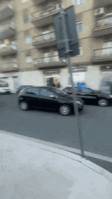 a blurry picture of a car driving down a street with a sign in the foreground