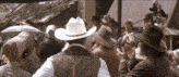 a group of people wearing cowboy hats are standing in a crowd