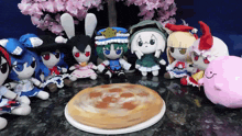 a group of stuffed animals are gathered around a pie