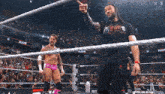 two wrestlers are standing in a wrestling ring and one has a shirt that says raw on it
