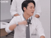 a man in a white shirt and tie with going seventeen written on the top