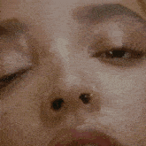 a close up of a woman 's face with a nose ring