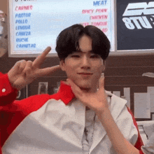 a man giving a peace sign in front of a sign that says carnes