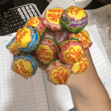 a hand is holding a bunch of chupa chips