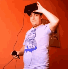a man wearing a shirt that says all year is holding a video game controller