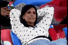 a woman is laying on a couch with her hands behind her head holding a christmas ball .