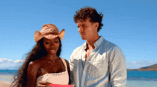 a man and a woman standing on a beach