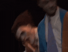 a group of men are standing in a dark room and one man is pointing at the camera .
