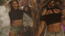 a group of women are dancing and one is wearing a black crop top