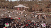 a large crowd of people watching a parade with the number 5 on the bottom right
