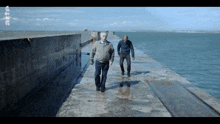 two men walking on a dock with the letters rtc on the bottom right