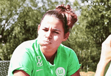 a woman wearing a green shirt with volkswagen on it