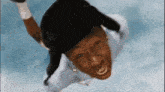 a man is flying through the air wearing a hat and a white shirt .