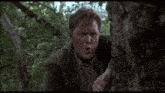 a man with a ring on his finger is standing in the woods