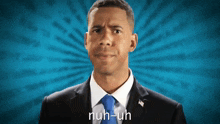 a man in a suit and tie says " nuh-uh " in front of a blue background