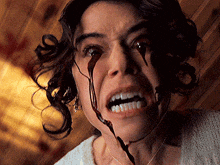 a close up of a woman with blood dripping from her eyes